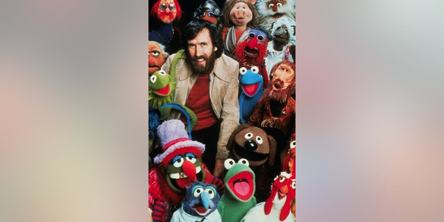 Jim Henson, American puppeteer and creator of "The Muppets," poses with his creations.