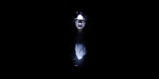 An actress dressed as a ghost scares people entering a "haunted school" during a Halloween celebration at a mall in Manila Oct. 31, 2012.