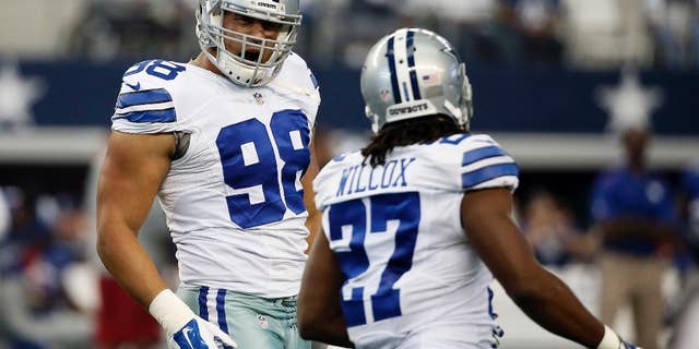 Dallas Cowboys defensive end Tyrone Crawford (98) and strong safety J.J. Wilcox (27) celebrate a defensive stop against the New York Giants during the first half of an NFL football game, Sunday, Oct. 19, 2014, in Arlington, Texas. (AP Photo/Brandon Wade)