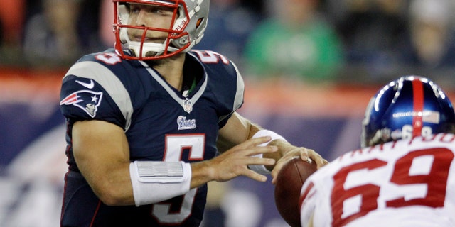 Aug. 29, 2013: New England Patriots quarterback Tim Tebow (5) looks for a receiver as New York Giants defensive end Justin Trattou (69) closes in during the third quarter of an NFL preseason football game in Foxborough, Mass.