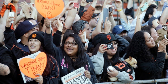 Oct. 29, 2012: San Francisco Giants fans cheer as the team buses arrive outside of AT&T Park in San Francisco.