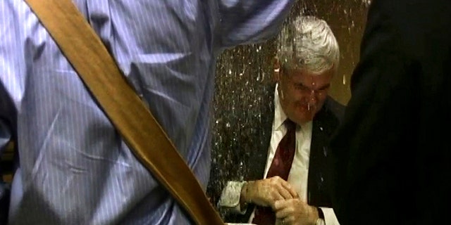May 17: In this image taken from video, a protester dumps glitter on a table where GOP presidential hopeful Newt Gingrich and his wife, Callista, were signing books at a hotel in Minneapolis.