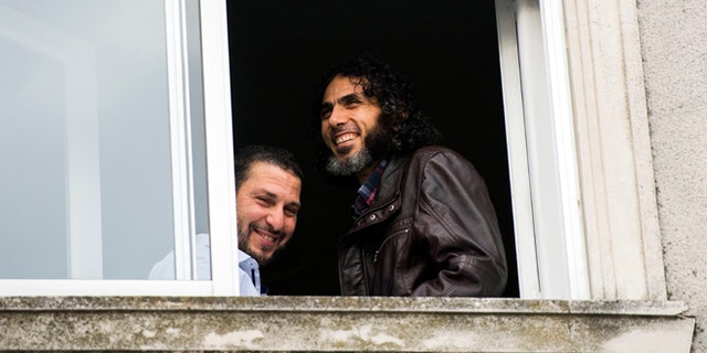 FILE - In this June 5, 2015 file photo, Abu Wa'el Dhiab, from Syria, right, and Adel bin Muhammad El Ouerghi, of Tunisia, both freed Guantanamo Bay detainees, stand next to the window of their shared home in Montevideo, Uruguay. The new U.S. ambassador in Uruguay expressed concern on Monday, July 11, 2016, about the lack of information on the whereabouts of Abu Wa'el Dhiab. (AP Photo/Matilde Campodonico, File)
