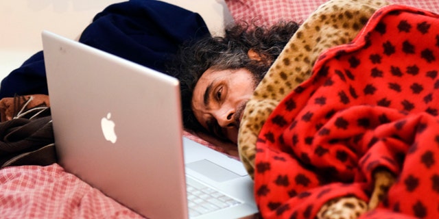 In this Friday, Sept. 9, 2016 photo, Syrian native Abu Wa'el Dhiab, a former Guantanamo detainee, rests in bed as he speaks to his family via a laptop, in his apartment in Montevideo, Uruguay. Activists and Uruguayan officials say the health of the former Guantanamo detainee resettled in the South American country is deteriorating as he continues a hunger strike at his home. Dhiab is demanding to leave Uruguay, which took him in with five other former Guantanamo prisoners in 2014. (AP Photo/Matilde Campodonico)