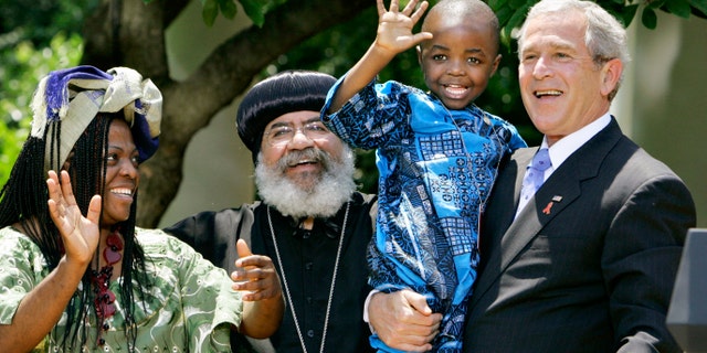 In this May 30, 2007, file photo President Bush, right, hoists 4-year-old Baron Mosima Loyiso Tantoh, son of Manyongo Mosima "Kuene" Tantoh of South Africa, left, who is HIV-positive, after speaking about his efforts to fight HIV/AIDS worldwide, in the Rose Garden of the White House in Washington. (AP Photo/J. Scott Applewhite, File)