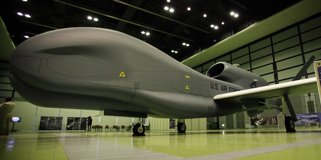 A mockup of Northrop Grumman's Unmanned Aerial Reconnaissance System RQ-4 Global Hawk is on display during a press briefing of the plane at a public exhibition hall in Tokyo, Wednesday, March 24, 2010. The Global Hawk can fly at altitudes of more than 60,000 feet for more than 32 hours and send near real-time reconnaissance imagery and signals intelligence data to forces in the air, on the ground and at sea.