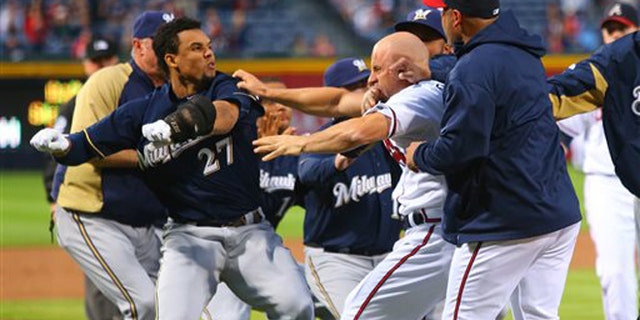 Carlos Gomez, left, and Atlanta Braves Reed Johnson exchange blows following a home run by Gomez on Wednesday, Sept. 25, 2013.