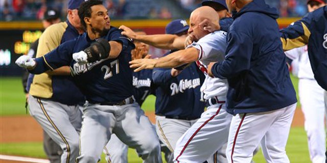 Carlos Gomez, left, and Atlanta Braves Reed Johnson exchange blows following a home run by Gomez on Wednesday, Sept. 25, 2013.