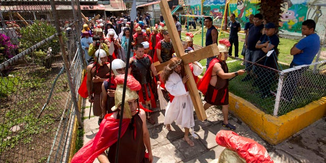 Inmate Aurelio Quevedo, carrying a cross, plays the role of Jesus during a reenactment of the Passion of Christ with fellow prisoners on Good Friday at the Mexico City Penitentiary during Holy Week in Mexico City, Friday, April 3, 2015. I behaved badly, Quevedo said in reference to his crime. But all of this leaves a good taste in the mouth, it generates repentance. Quevedo is a 37-year-old taxi driver serving a 49-year sentence for kidnapping. (AP Photo/Eduardo Verdugo)