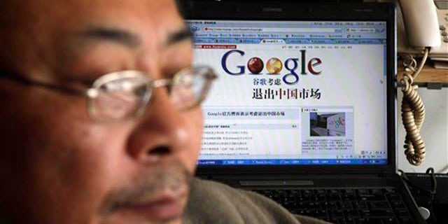 Award winning Chinese blogger Tiger Temple, or Zhang Shihe, a critic of China's internet censorship, is seen with a webpage with the Chinese words "Google considers leaving the Chinese market" in his home in Beijing, Tuesday, March 23, 2010. Google Inc. stopped censoring the Internet for China by shifting its search engine off the mainland Monday but said it will maintain other operations in the country. (AP Photo/ Gemunu Amarasinghe)