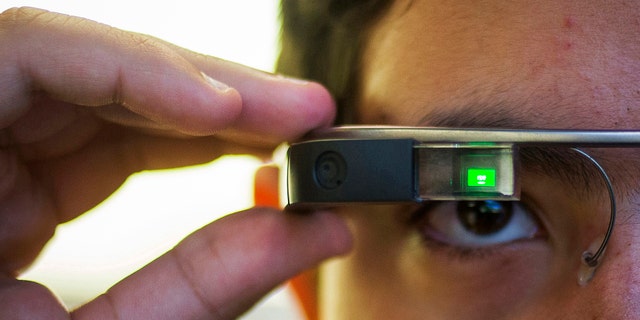 File photo - Tiago Amorim of Brazil, poses with a Google Glass eyewear frame in Manhattan, New York Sept. 19, 2014.
