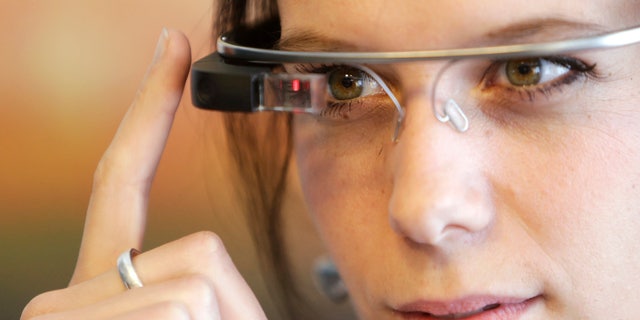 A woman wears Google glasses after a media presentation of a Google apartment in Prague May 15, 2014. The apartment is fully equipped with newest Google technologies and members of the media were shown how to use them in common life situations at home. REUTERS/David W Cerny (CZECH REPUBLIC - Tags: BUSINESS SCIENCE TECHNOLOGY) - RTR3PB0Q
