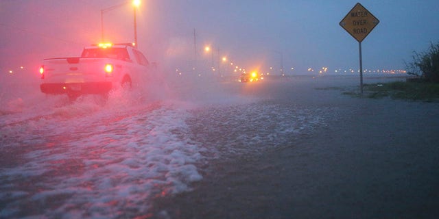 Trucks with the Alabama Department of Transportation work to block off a flooded part of US Highway 98 while fighting rain from Tropical Storm Gordon on Wednesday, Sept. 5, 2018, in Spanish Fort, Ala. Tropical Storm Gordon never became a hurricane but it was deadly all the same, as it made landfall late Tuesday just west of the Alabama-Mississippi border. (AP Photo/Dan Anderson)