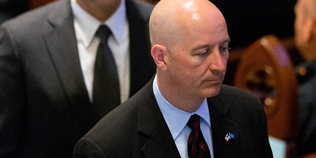 Nebraska Gov. Pete Ricketts at the funeral service for Omaha police detective Kerrie Orozco Tuesday, May 26, 2015. The state senate overrode his veto, allowing immigrants who arrived here as kids drivers' license. (Matt Miller/The World-Herald via AP, Pool)