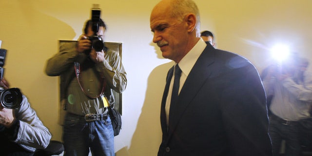 Greek Prime Minister George Papandreou returns to an emergency cabinet meeting after he took a short break at the Greek parliament in Athens, on Thursday, Nov. 3, 2011. A spokesman for Greece's government says it is prepared to discuss an opposition demand for the creation of a transitional government to approve the latest European bailout deal and secure the next installment of rescue loans for the country. (AP Photo/Thanassis Stavrakis)