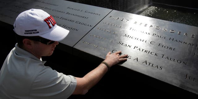 July 4- US Army PFC Kyle Hockenberry of Marietta, Ohio, touches the name of a first responder etched in the 9/11 Memorial at ground zero in New York.