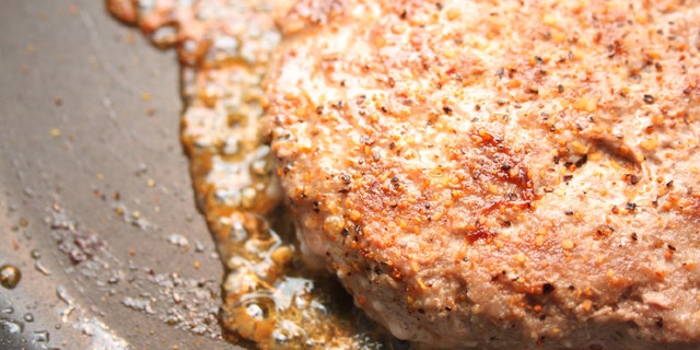 A turkey burger in a frying pan.