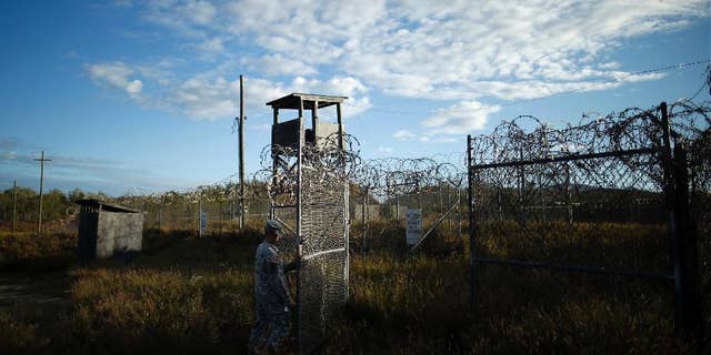 FILE - In this Nov. 13, 2013, file photo reviewed by the U.S. military, a soldier closes the gate at the now abandoned Camp X-Ray, which was used as the first detention facility for al-Qaida and Taliban militants who were captured after the Sept. 11 attacks at Guantanamo Bay Naval Base, Cuba. During six years behind bars at Guantanamo Bay, Abdul Rauf insisted he was a lowly Taliban foot soldier, even though he was really a corps commander. Rauf was released in 2007 and sent home to Afghanistan. He was working as the top recruiter in Afghanistan for Islamic State militants when a drone strike on Feb. 9, 2015, killed him along with seven others. (AP Photo/Charles Dharapak, File)