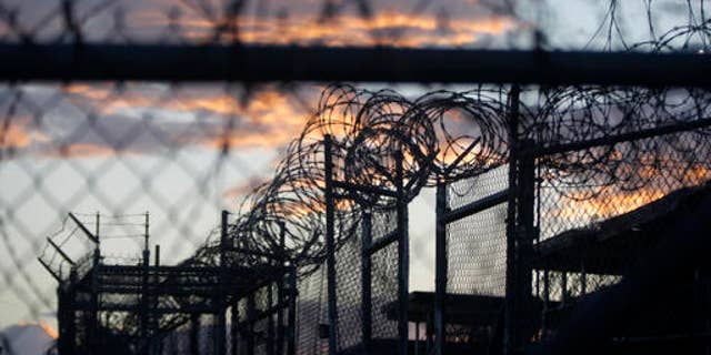 FILE - In this Nov. 21, 2013 file photo reviewed by the U.S. military, dawn arrives at the now closed Camp X-Ray, which was used as the first detention facility for al-Qaida and Taliban militants who were captured after the Sept. 11 attacks, at the Guantanamo Bay Naval Base, Cuba. A recently released transcript from the U.S. base at Guantanamo Bay, Cuba, features new allegations of involvement in terrorism by officials in Saudi Arabia, including an unnamed member of the royal family. (AP Photo/Charles Dharapak, File)