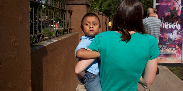 In this Friday, Sept. 7, 2012 photo, Jessica Hooker, left, carries her adopted son Daniel in Guatemala City. (AP Photo/Moises Castillo)