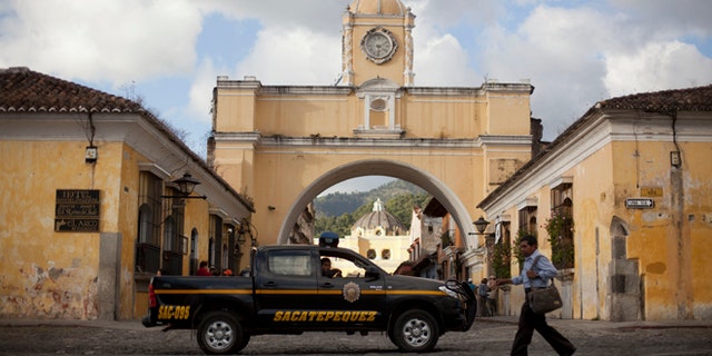 In this Nov. 14, 2013 photo, police patrol along a main street close to the Santa Catalina convent in Antigua, Guatemala. Vehicle and home burglaries are up, and once-reliable public services such as water and trash collection have been left unattended across whole blocks.  (AP Photo/Luis Soto)