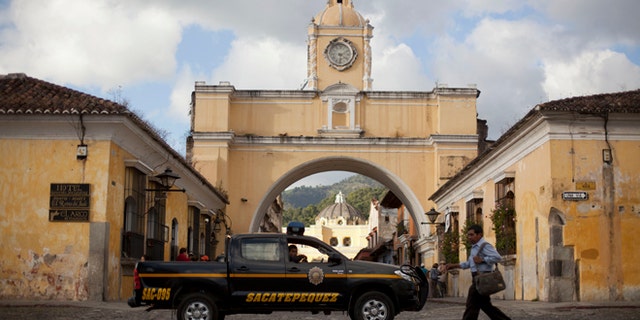 In this Nov. 14, 2013 photo, police patrol along a main street close to the Santa Catalina convent in Antigua, Guatemala. Vehicle and home burglaries are up, and once-reliable public services such as water and trash collection have been left unattended across whole blocks. (AP Photo/Luis Soto)