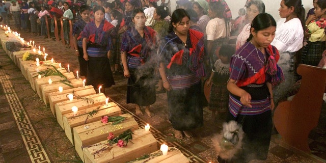 391523 03: Guatemalan Mayan Quiche Indian women dance and burn incense around 41 coffins of victims, found in a 1980''s clandestine cemetery, during mass July 5, 2001 in Zacualpa, Quiche, 150 miles northwest of Guatemala''s capital. According to the Guatemalan Anthropology Forensic Foundation, the cemetery is just one of 669 that has resulted from a 36-year civil war that left 200,000 missing people in the country. (Photo by Andrea Nieto/Getty Images)