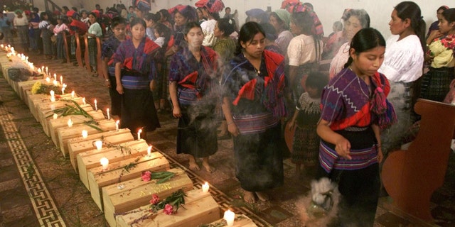 391523 03: Guatemalan Mayan Quiche Indian women dance and burn incense around 41 coffins of victims, found in a 1980''s clandestine cemetery, during mass July 5, 2001 in Zacualpa, Quiche, 150 miles northwest of Guatemala''s capital. According to the Guatemalan Anthropology Forensic Foundation, the cemetery is just one of 669 that has resulted from a 36-year civil war that left 200,000 missing people in the country. (Photo by Andrea Nieto/Getty Images)