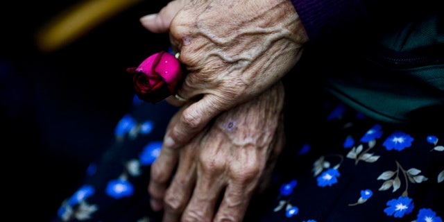 FILE - In this Aug. 2, 2011 file photo, Cristina Alfaro Mejia, whose husband and daughter were killed by soldiers during a massacre in the community of Dos Erres in 1982, holds a rose while waiting for the sentencing of soldiers in Guatemala City. The court sentenced three former special forces soldiers to 6,060 years in prison each for the massacre of more than 200 men, women and children during Guatemala's 36-year civil war which ended in 1996. The story of the massacre is told in ââ¬ÅFinding Oscar,ââ¬Â a documentary executive-produced by Steven Spielberg that premieres in Sept. 2016 at the Telluride Film Festival in Colorado. (AP Photo/Rodrigo Abd, File)