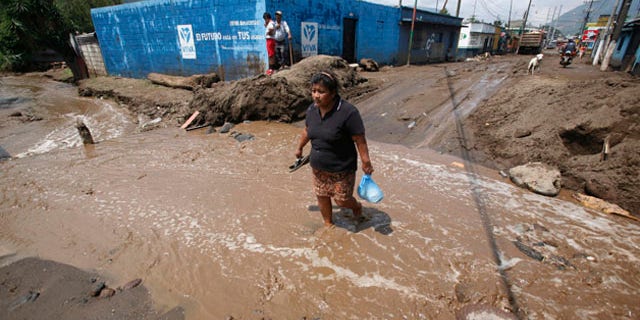June 1: A woman crosses a flooded way after the Mico river overflowed due to heavy rains from tropical storm Agatha in Amatitlan, Guatemala. (AP)