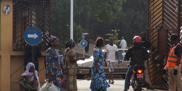 People walk in front of the entrance of the Donka Hospital, where victims of the ebola disease are being treated, in Conakry, Guinea.