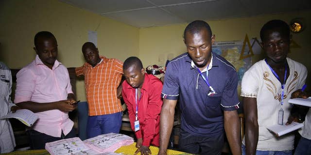 Electoral officials sort out ballot papers at the end of presidential elections in Conakry, Guinea, Sunday, Oct. 11, 2015. Guinea's president and main opposition candidate called for calm Sunday when they voted in the country's presidential election, after days of electoral clashes. (AP Photo/Youssouf Bah)