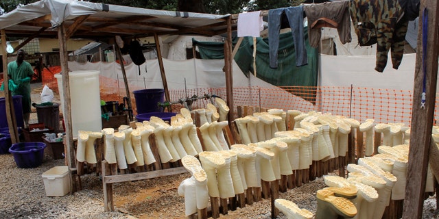 Aug. 20, 2014: In this photo, boots worn by health workers as part of their personal protective equipment are placed on racks to dry after they were washed at a Doctors Without Borders Ebola care center in Conakry, Guinea.