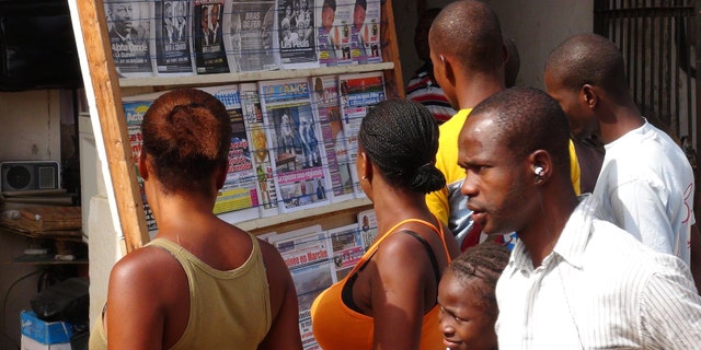 People read news headlines at a newsstand in Conakry, Guinea, March 28, 2014. (REUTERS/Saliou Samb)