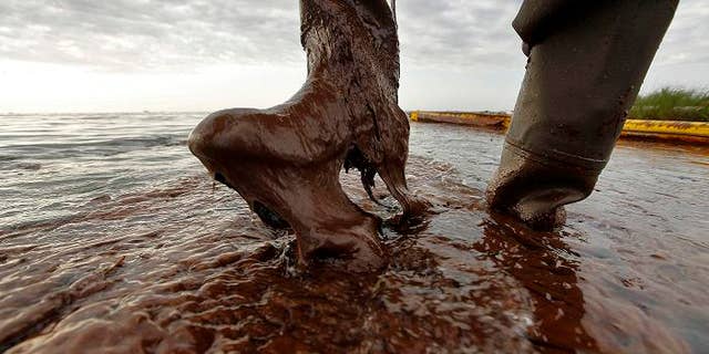 June 5: In this file photo, Plaquemines Parish coastal zone director P.J. Hahn lifts his boot out of thick beached oil at Queen Bess Island in Barataria Bay, just off the Gulf of Mexico in Plaquemines Parish, La.