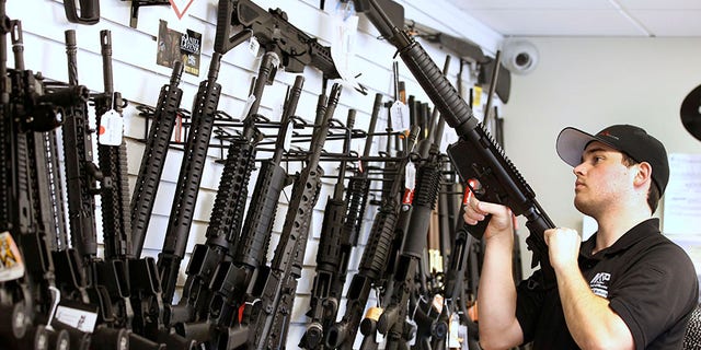 Salesman Ryan Martinez clears the chamber of an AR-15 at the "Ready Gunner" gun store In Provo, Utah.