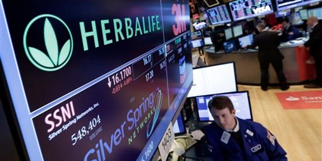 Specialist Peter Elkins foreground, works at the post that handles Herbalife, on the floor of the New York Stock Exchange, Thursday, Jan. 23, 2014. Herbalife Ltd. shares fell Thursday after U.S. Sen. Edward Markey called for an investigation into the company's business practices. (AP Photo/Richard Drew)