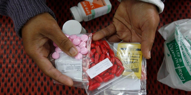 An HIV-infected patient displays medicine at a hospital in Payao province, about 373 miles north of Bangkok.