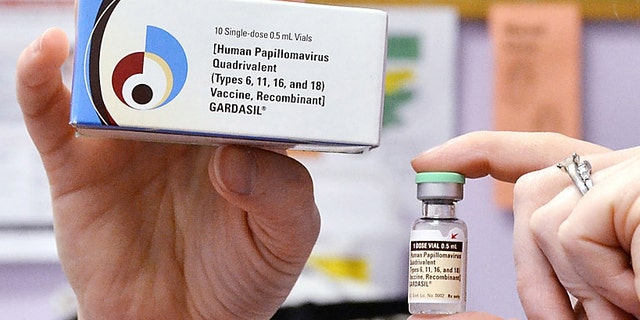 FILE - A child health nurse holds up a vial and box for the HPV vaccine, brand name Gardasil, at a clinic in Kinston, N.C. on Monday March 5, 2012. A vaccine against a cervical cancer virus has cut infections in teen girls by half, according to a study released Wednesday, June 19, 2013. The study confirms research done before the HPV vaccine came on the market in 2006. But this is the first evidence of how well it works now that it is in general use. (AP Photo/Daily Free Press, Charles Buchanan)
