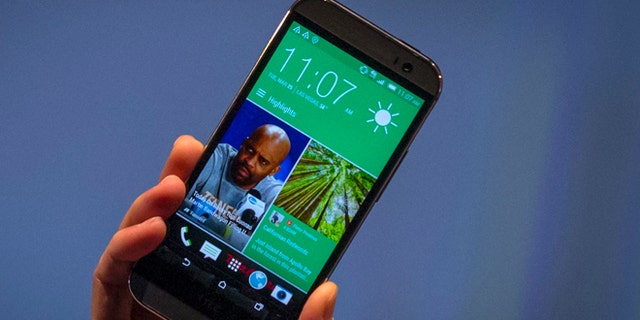 March 25, 2014: HTC CEO Peter Chou shows the new HTC One M8 phone during a launch event in New York.