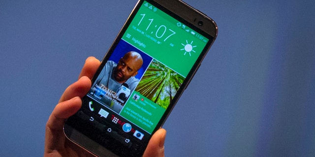 March 25, 2014: HTC CEO Peter Chou shows the new HTC One M8 phone during a launch event in New York.