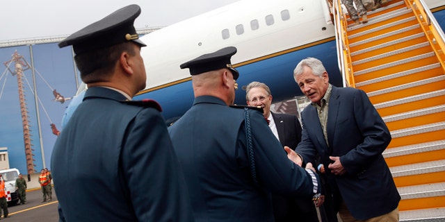 U.S. Defense Secretary Chuck Hagel shakes hands with military officers upon arriving in Mexico City Wednesday, April 23, 2014. (AP Photo/Shannon Stapleton, Pool)