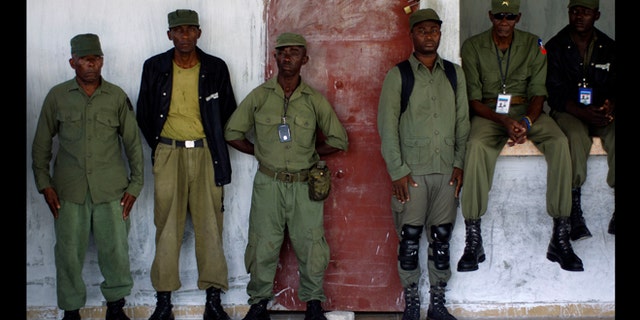 April 24, 2012: Members of the dissolved Haitian army and civilian volunteers listen to a military veteran during a press conference at an army barracks just outside Haiti's capital, Port-au-prince.