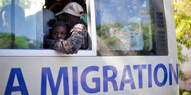 People who were deported by Dominican Republic authorities sit in a bus at a shelter as they are taken to Haitian towns where they have family, in Croix-des-Bouquets, Haiti, Monday, Nov. 25, 2013. Expulsions and voluntary departures from the DR to Haiti follow violence that engulfed the town of Neiba in the southwestern corner of the Dominican Republic. Relations between the two have soured since September when a Dominican court threatened to revoke citizenship for residents of the Dominican Republic of Haitian descent. (AP Photo/Dieu Nalio Chery)