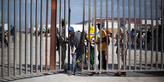 In this Nov. 12, 2013 photo, a Haitian man crosses into Haiti along the border with Jimani, Dominican Republic.