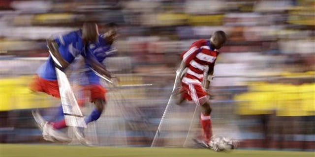 Jan. 10, 2011: A player belonging to Haiti's unofficial national amputee soccer team, right, controls the ball as two players from the local Zaryen team attempt to defend in a friendly match at the national stadium in Port-au-Prince, Haiti. The game is one of many events planned to mark the one-year anniversary of the Jan. 12th magnitude-7.0 quake that killed more than 220,000 people and left millions homeless. Many of the players from both teams lost their limbs in the earthquake. (AP)