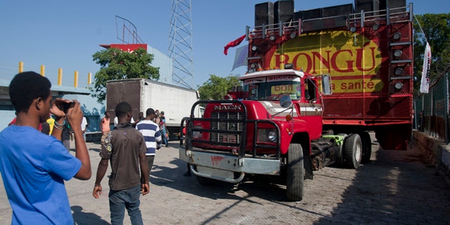 Feb. 17, 2015: A man takes pictures of the float on which a singer was electrocuted by an overhead power line as the float passed beneath it during a carnival parade in Port-au-Prince, Haiti. At least 20 people were killed early Tuesday after he was electrocuted, setting off a panic in which dozens of people were trampled, witnesses and officials said.