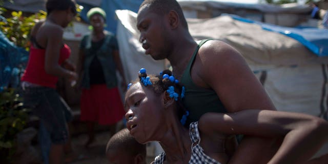 Refugees react to the effects of tear gas fired by police and UN soldiers during a protest in an area where displaced earthquake survivors live in Port-au-Prince, Haiti, Thursday, Nov. 18, 2010. Following days of rioting in northern Haiti over suspicions that U.N. soldiers introduced a cholera epidemic that has killed more than 1,000 people, protesters in Haiti's capital clashed with police Thursday lashing out at U.N. peacekeepers and the government, blocking roads and attacking foreigners' vehicles. (AP Photo/Emilio Morenatti) (AP Photo/Ramon Espinosa)