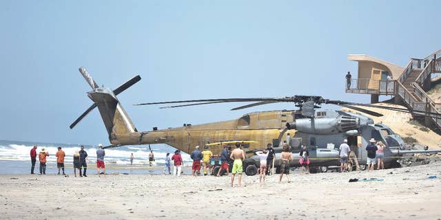 FILE -In this Wednesday, April 15, 2015 file photo, a Marine Corps CH-53E helicopter sits in the sand where it made an emergency landing in Solana Beach, Calif. One Marine has been killed and 9 others were hurt when a helicopter made a hard landing at Camp Lejeune in North Carolina, Wednesday night, Sept. 2, 2015. (AP Photo/Lenny Ignelzi, File)
