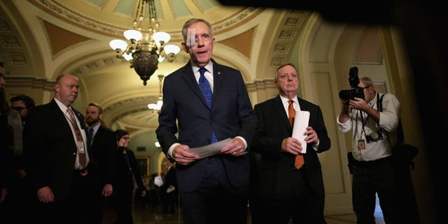 WASHINGTON, DC - FEBRUARY 03: Senate Minority Leader Harry Reid (D-NV) (C) and Senate Minority Whip Richard Durbin (D-IL) (2nd R) arrive for a news conference after the weekly Democratic Senate policy luncheon at the U.S. Capitol February 3, 2015 in Washington, DC. Reid is wearing a bandage over his right eye after undergoing surgery to repair damage from an exercise accident. (Photo by Chip Somodevilla/Getty Images)